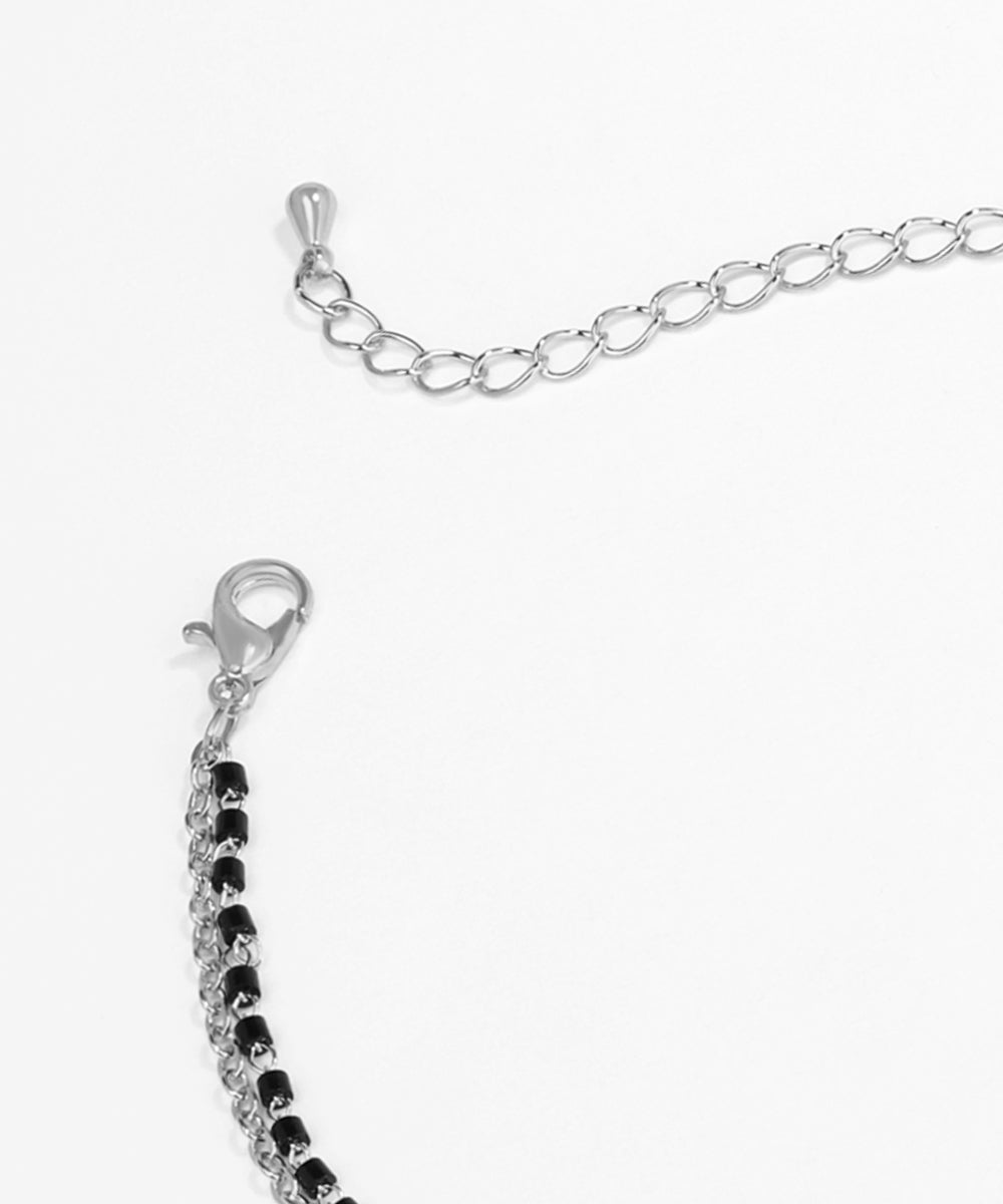 Silver bracelet with black beads on a white background