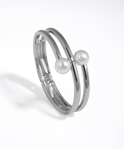 Silver bracelet with two pearls on a white background