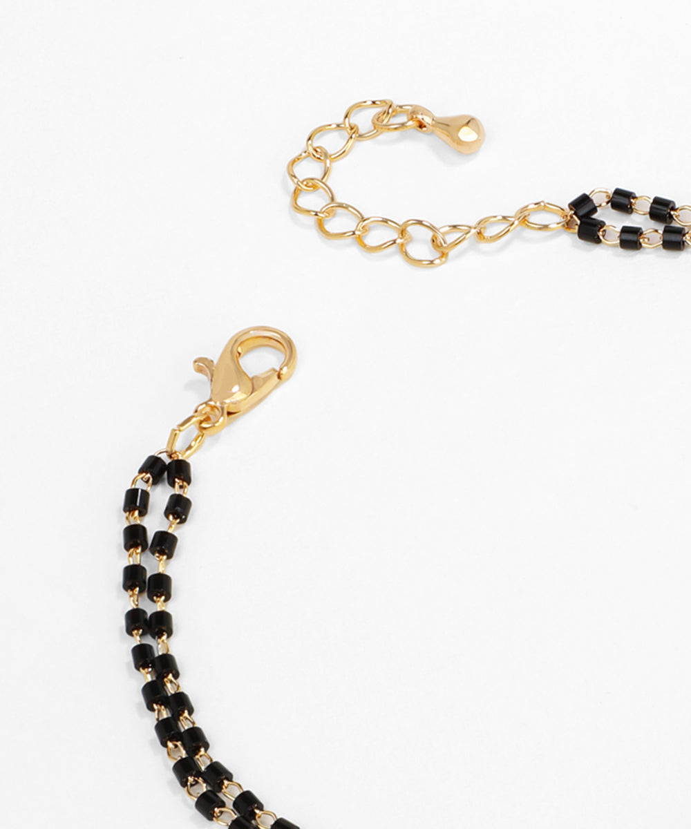 Black beaded chain with gold clasp on a white background