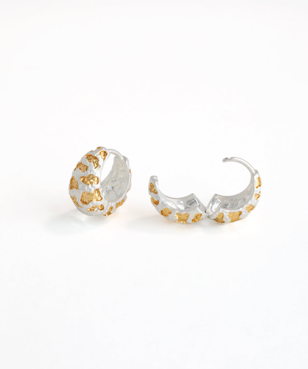 Pair of silver and gold hoop earrings on a white background