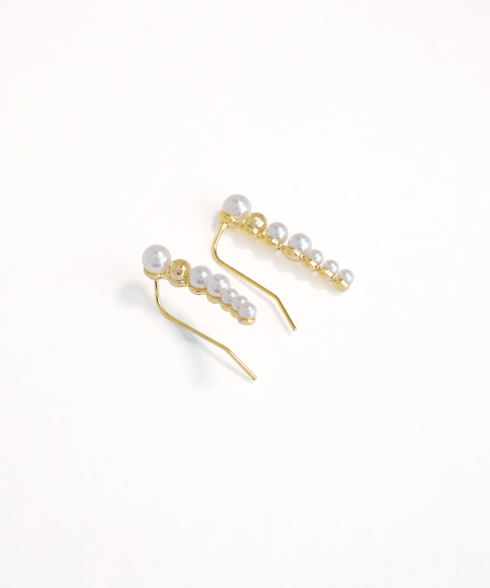 Gold earrings with pearls on a white background