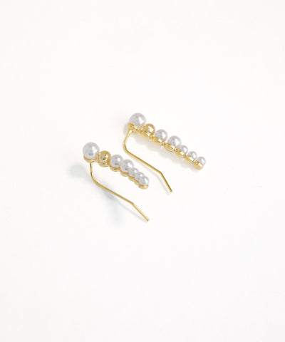Gold earrings with pearls on a white background