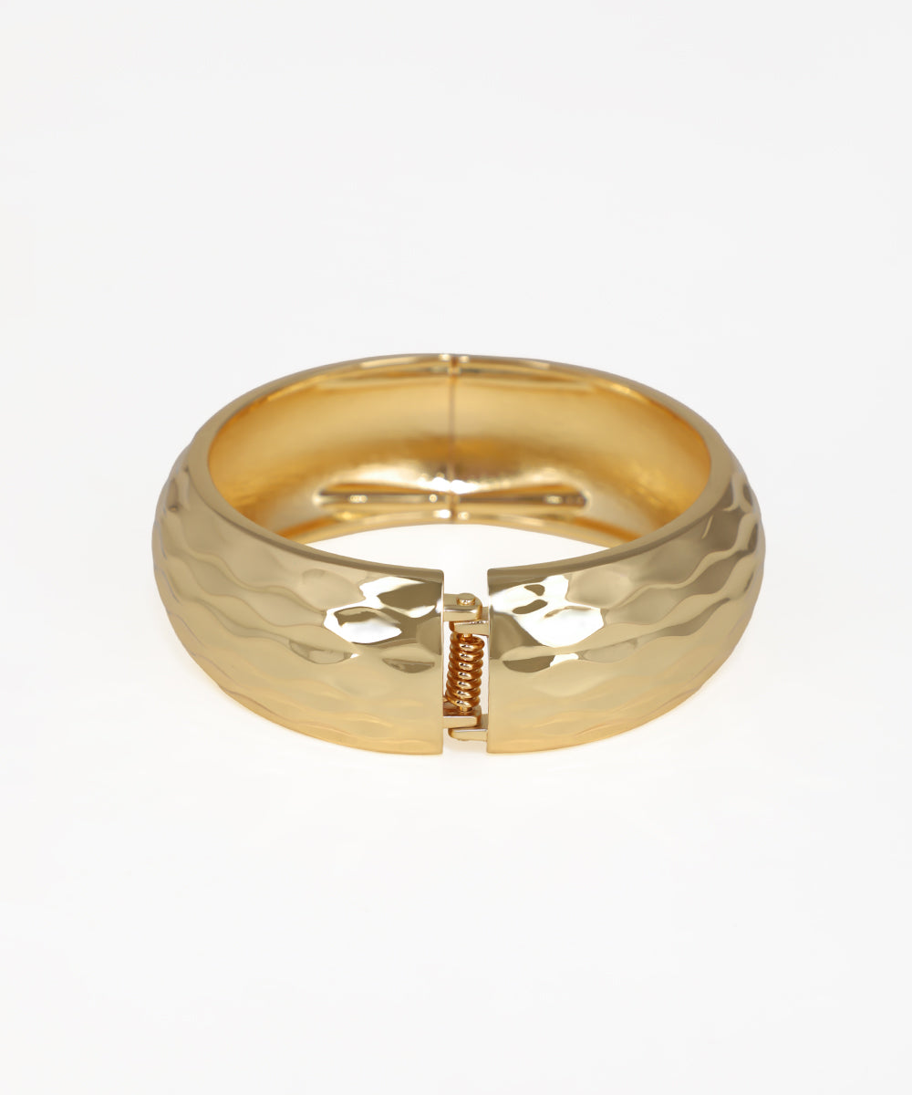 Gold ring with a unique design on a white background