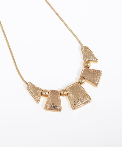 Gold necklace with geometric pendants on a white background