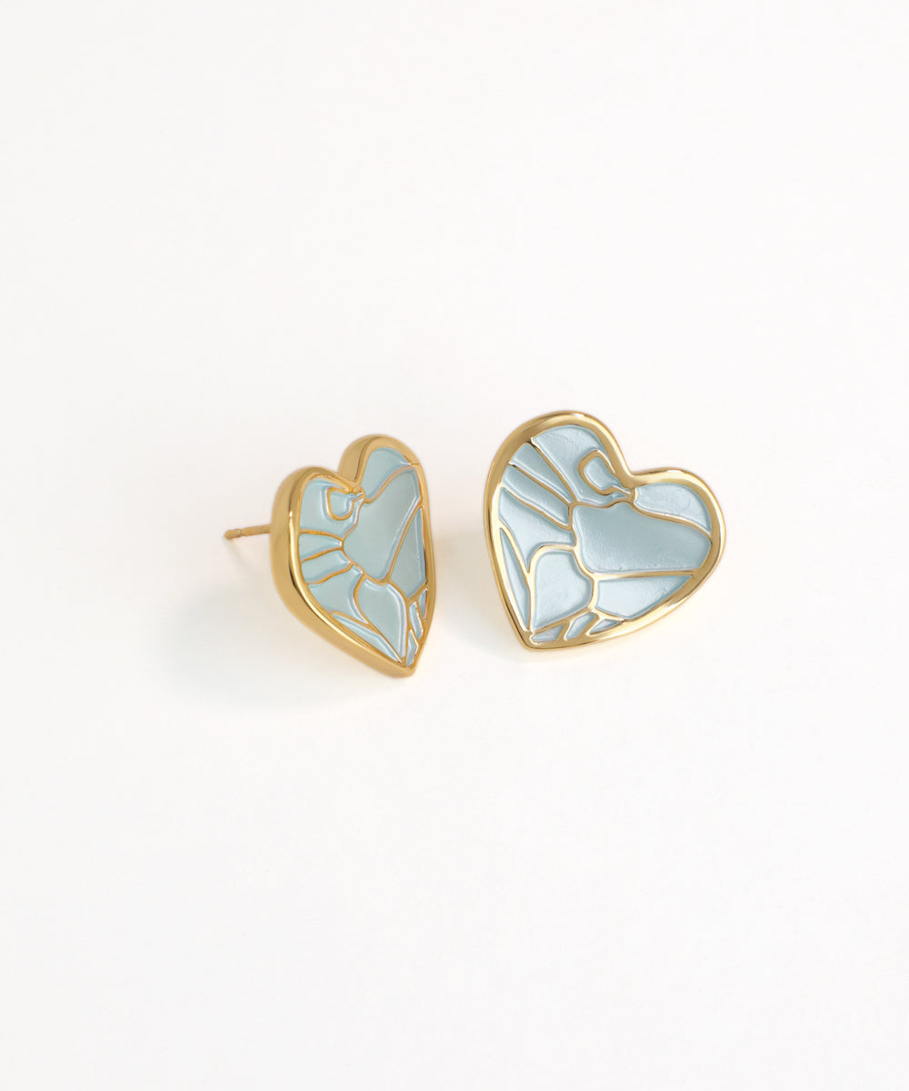 Heart-shaped earrings with gold frames and light blue enameled design on a white background