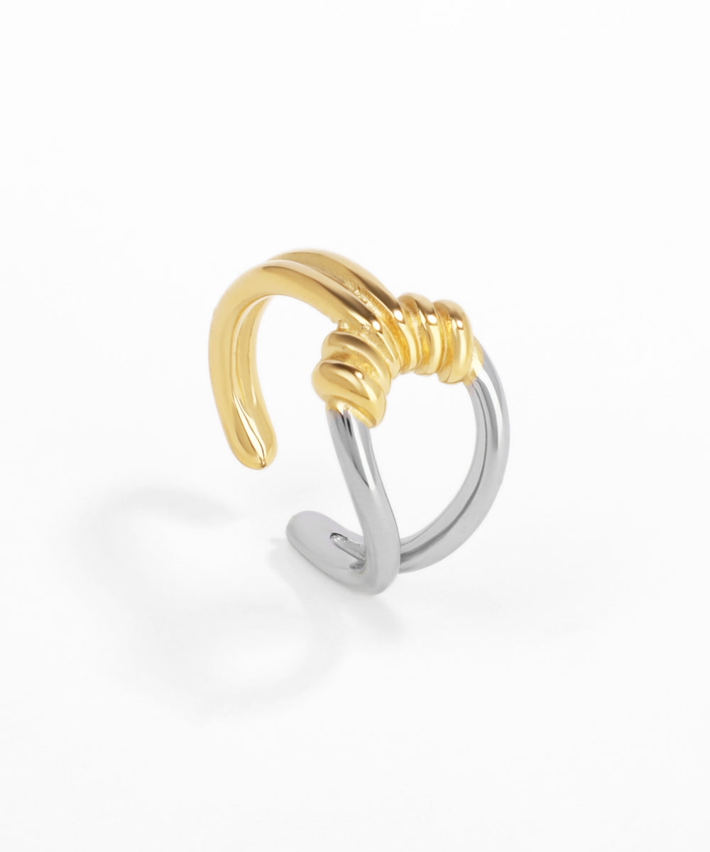 Gold and silver ear cuff on a white background