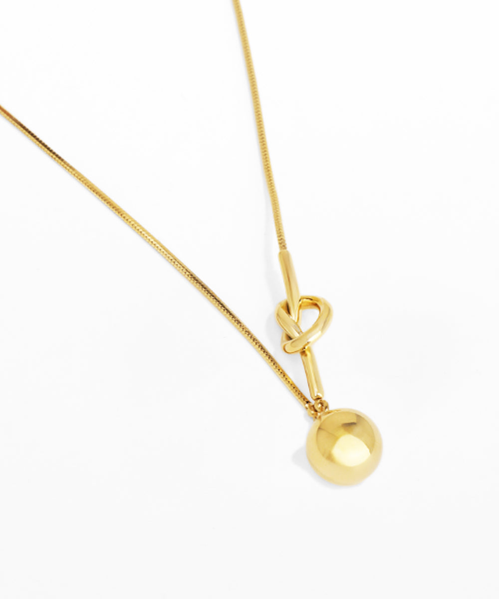 Gold necklace with a round pendant on a white background
