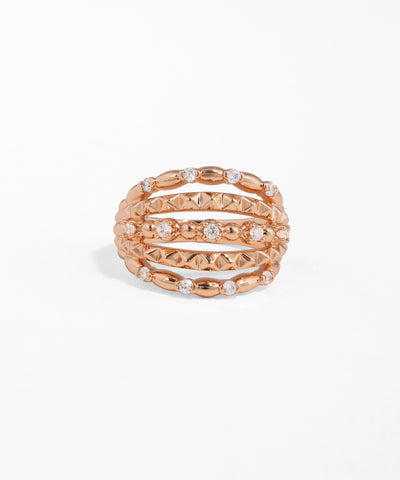Rose gold stackable rings with embedded stones on a white background