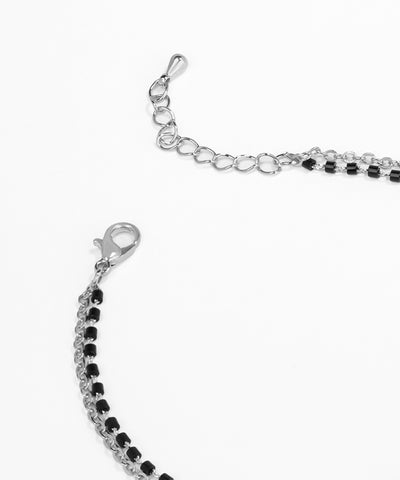 Silver bracelet with black beads on a white background