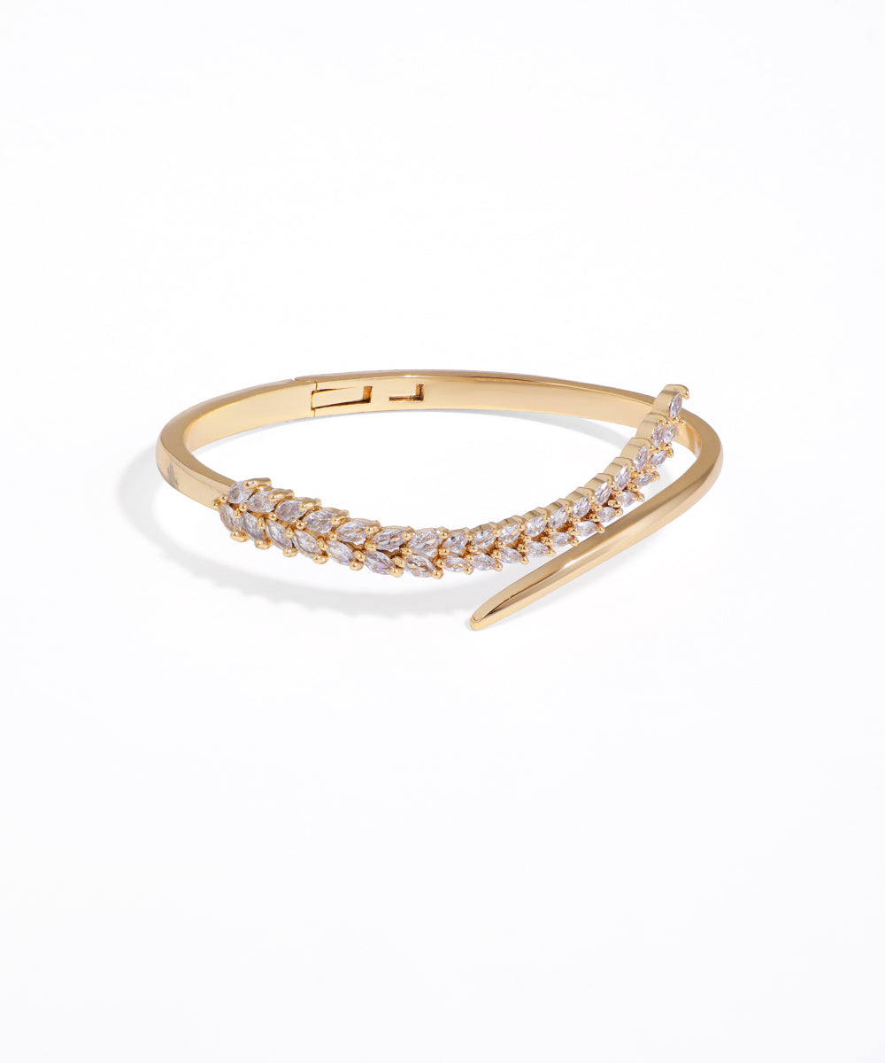 Gold bracelet with clear stones on a white background