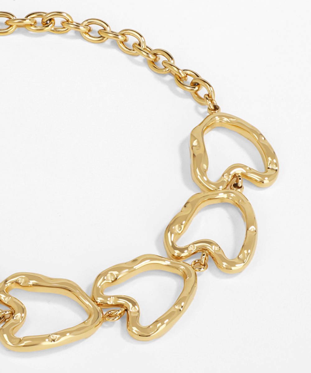 Gold chain bracelet with heart-shaped links on a white background