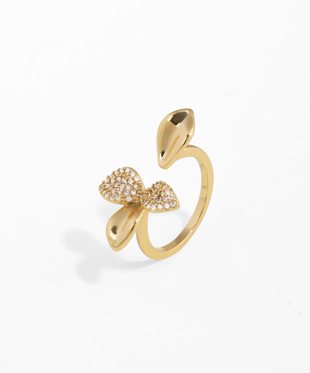 Gold-tone open ring with sparkling bow and polished teardrop design