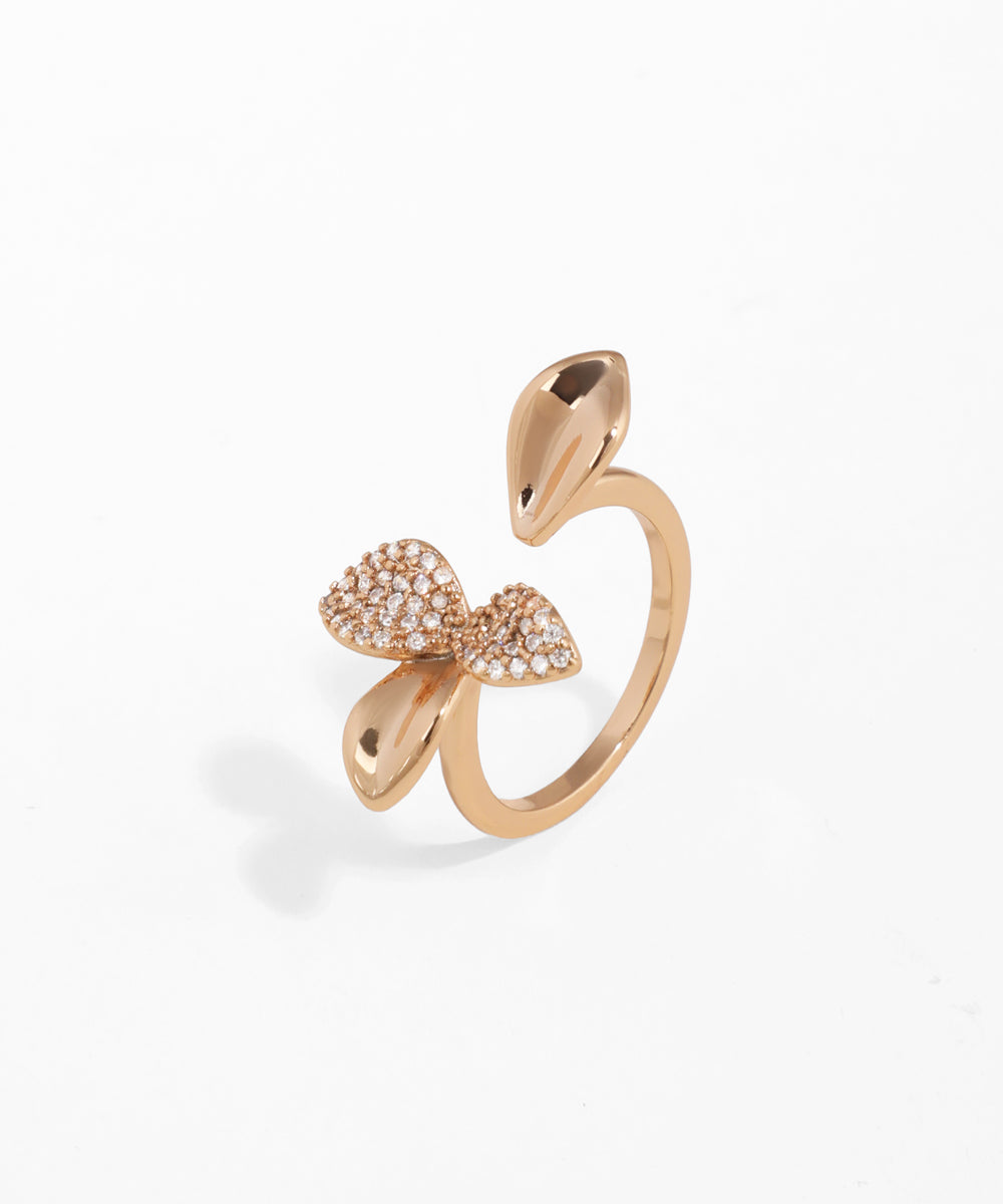 Rose gold bow-shaped ring on a white background