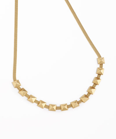 Gold necklace with pyramid-shaped beads on a white background