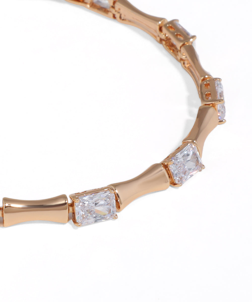 Rose gold bracelet with diamond accents on a white background