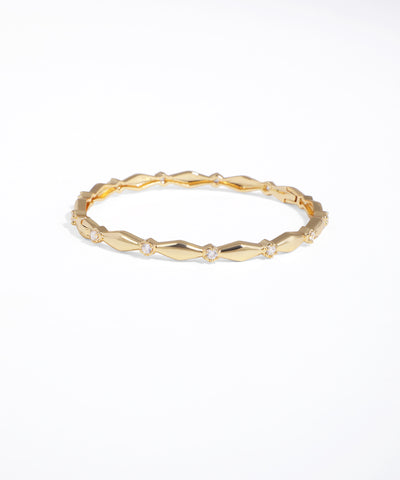 Gold ring with geometric design on a white background