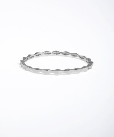 Silver ring with a textured design on a white background