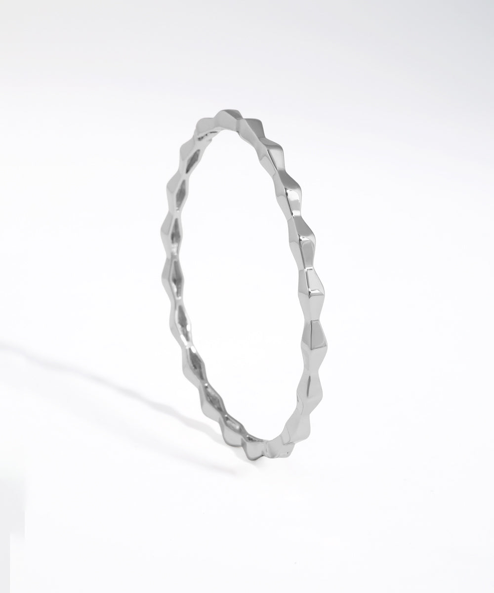 Silver bracelet with a textured design on a white background