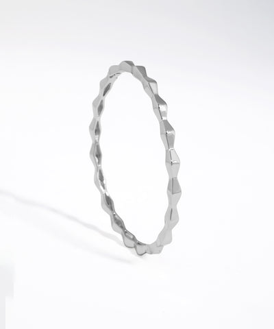 Silver bracelet with a textured design on a white background