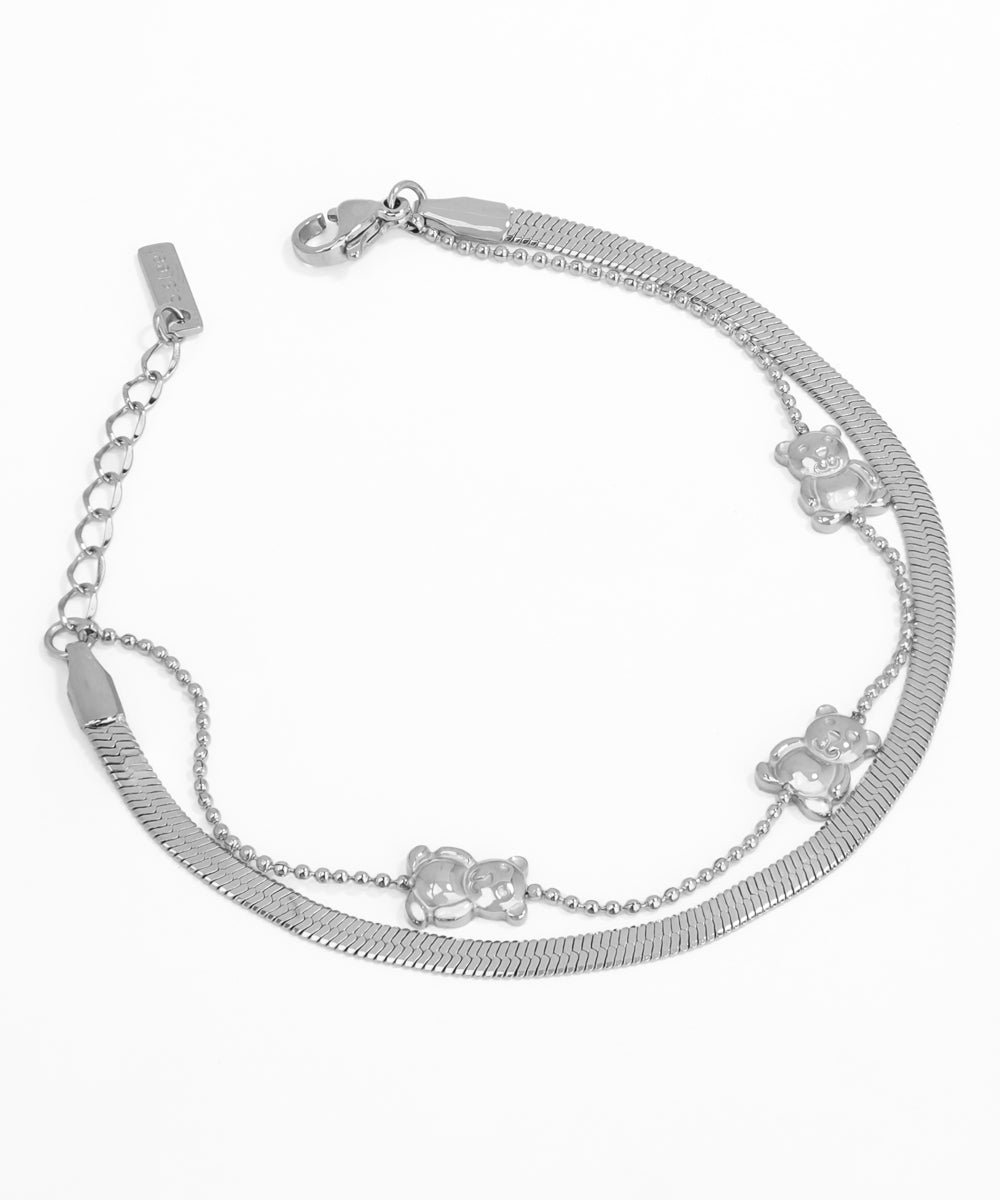 Silver bracelet with chain and flower charms on a white background