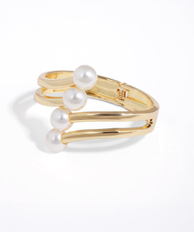 Gold-tone multi-band bracelet with a linear row of four white faux pearls.