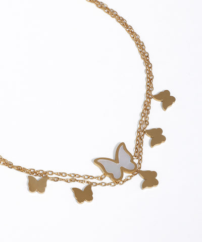 Gold and silver butterfly charm necklace on a white background