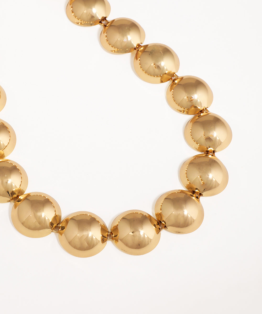 Gold beaded necklace on a white background