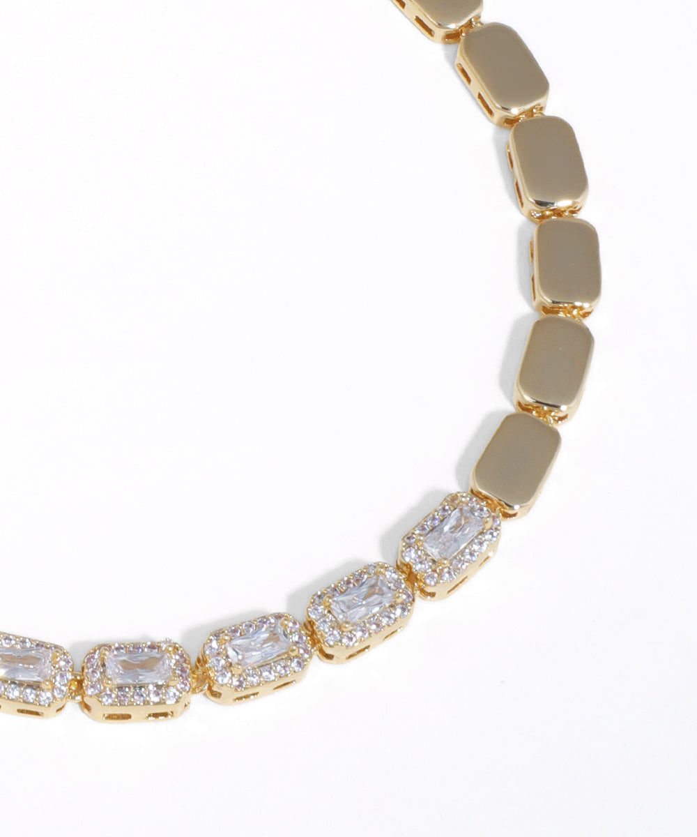 Gold bracelet with clear gemstones on a white background