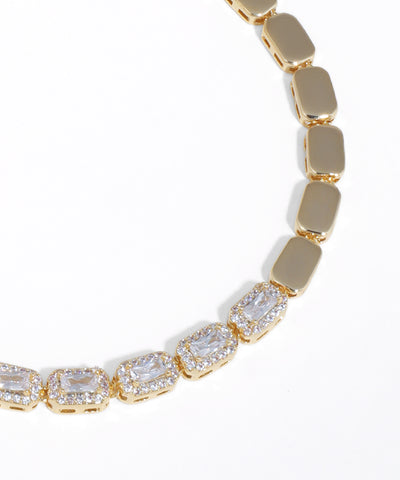 Gold bracelet with clear gemstones on a white background