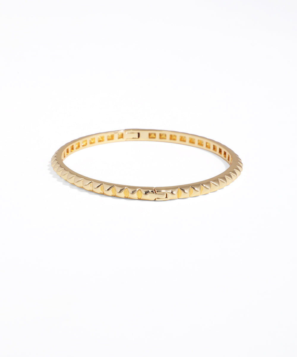 Gold ring with textured band on a white background