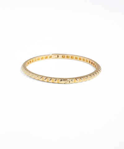 Gold ring with textured band on a white background