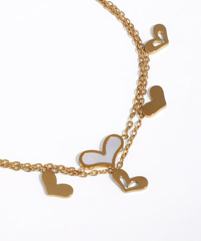 Gold necklace with heart-shaped pendants on a white background