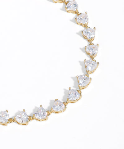 Gold bracelet with clear gemstones on a white background