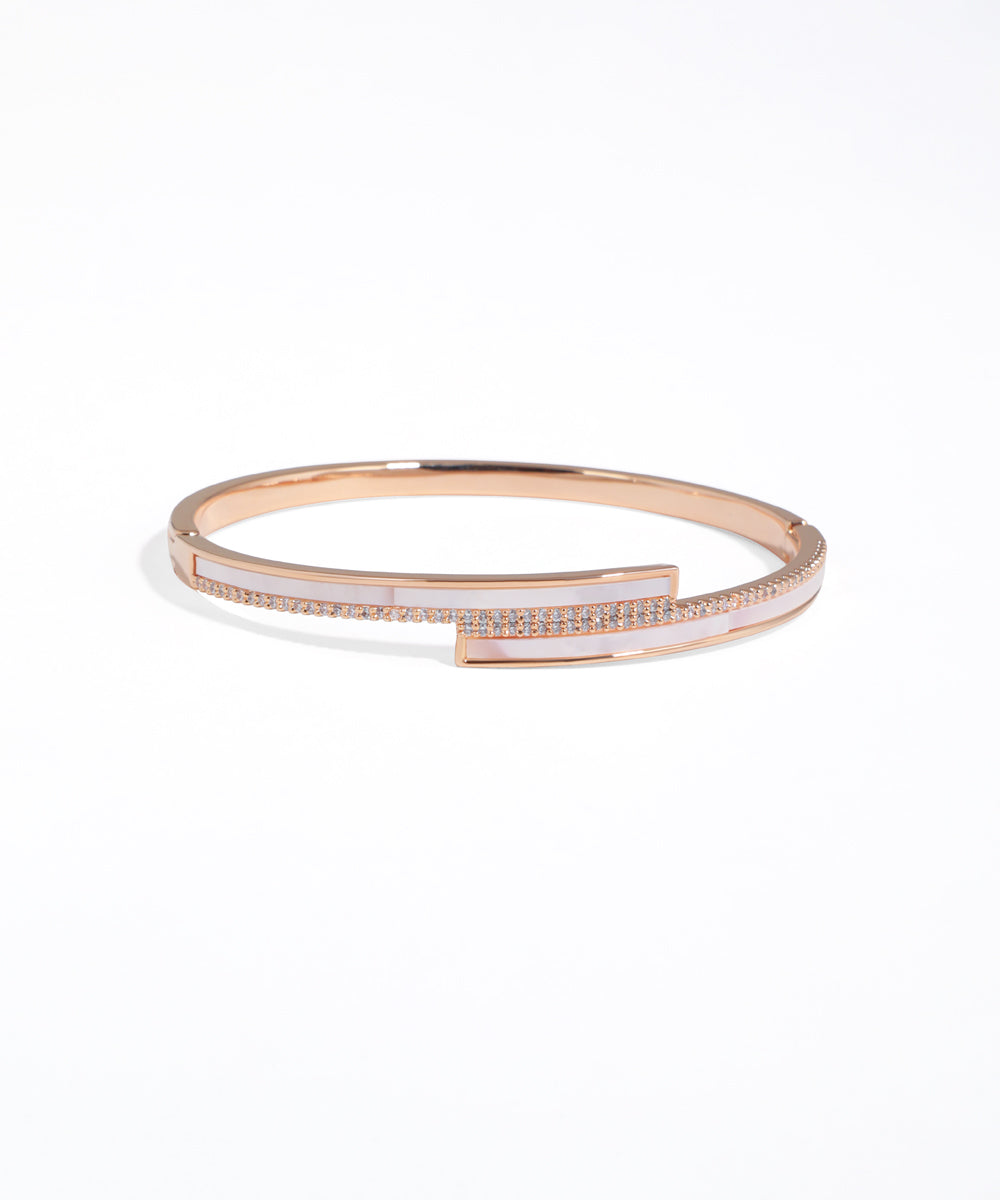 Rose gold bracelet with small rectangular gemstones on a white background