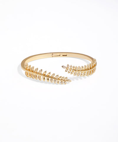 Gold bracelet with leaf-like design on a white background