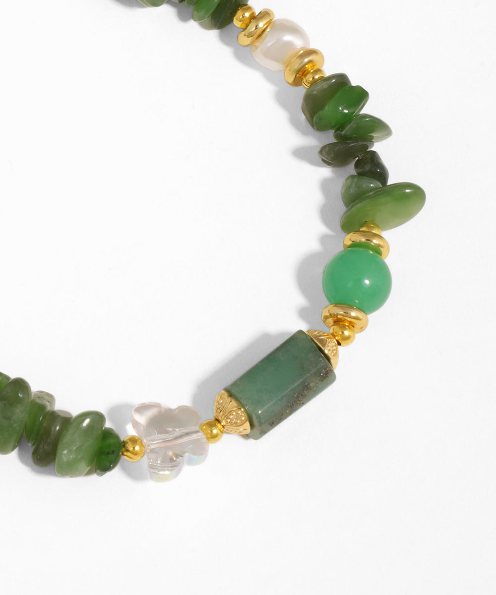 Green beaded necklace with gold accents on a white background