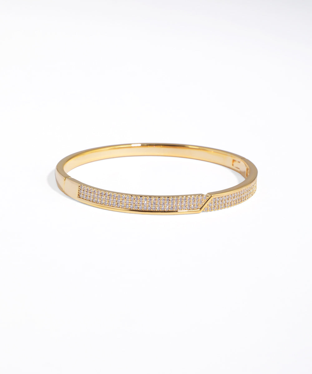 Gold bracelet with embedded stones on a white background