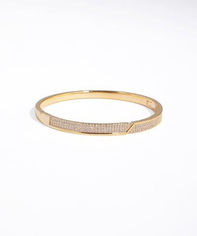 Gold bracelet with embedded stones on a white background