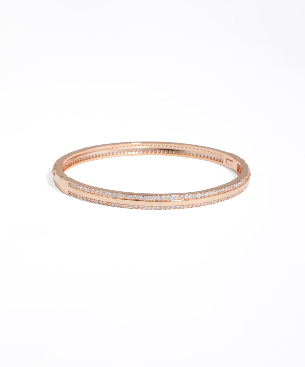 Rose gold bracelet with clear stones on a white background