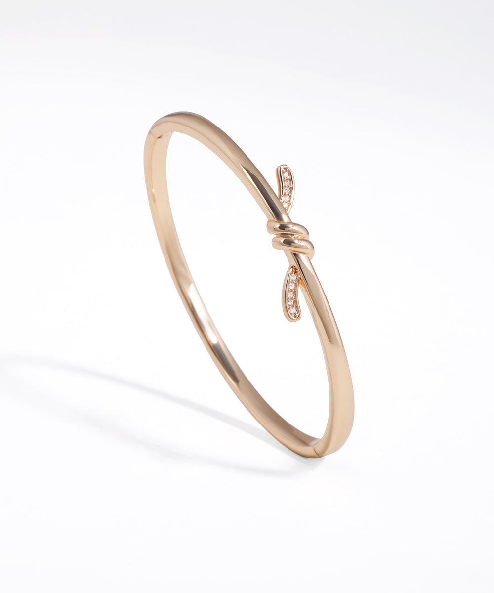 Rose gold bracelet with a subtle design on a white background