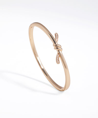 Rose gold bracelet with a subtle design on a white background