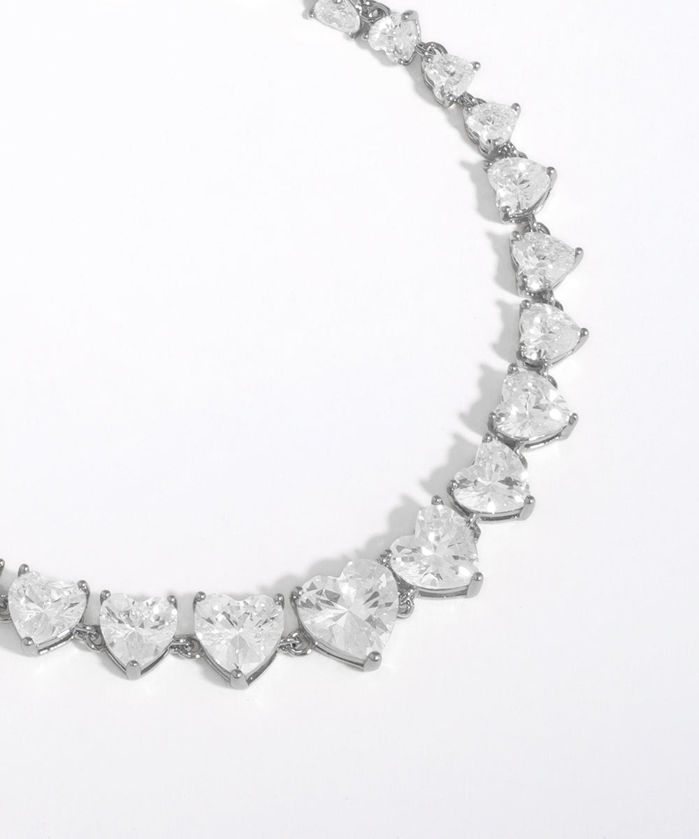 Heart-shaped diamond necklace on a light gray background