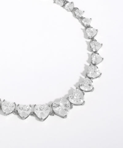 Heart-shaped diamond necklace on a light gray background
