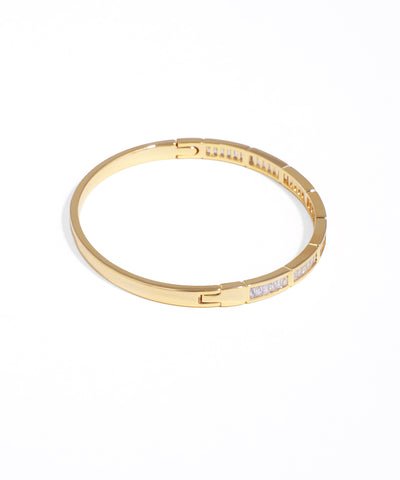 Gold bracelet with embedded stones on a white background