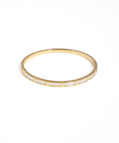 Gold bangle with embedded stones on a white background