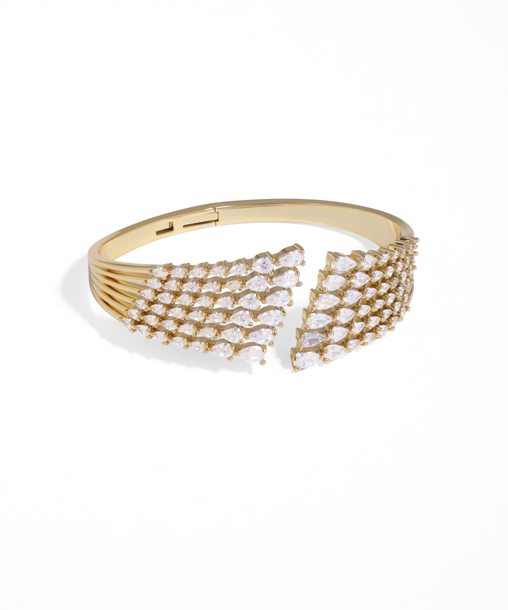 Gold bracelet with clear gemstones on a white background