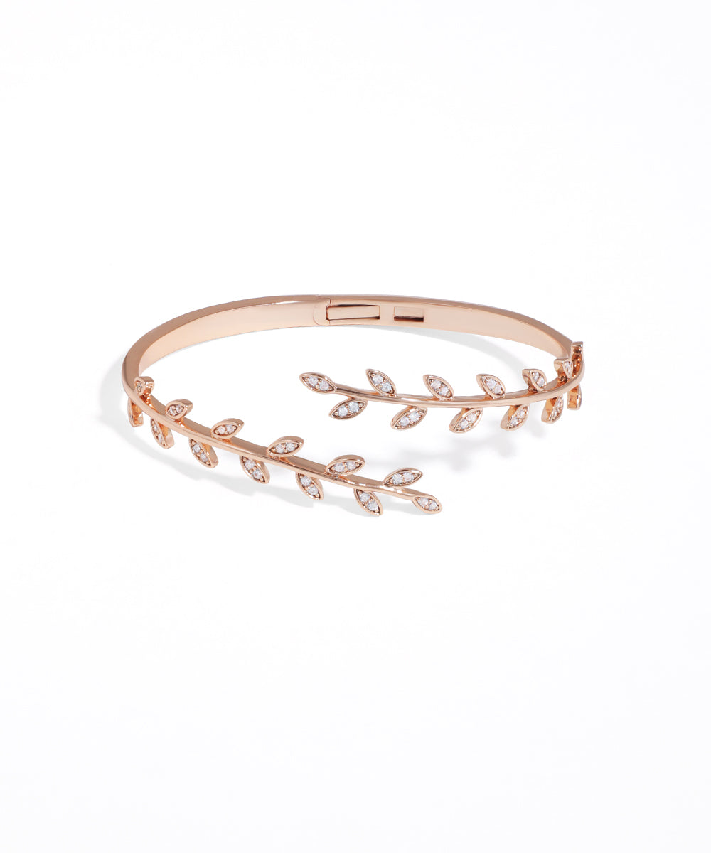 Rose gold bracelet with leaf design on a white background