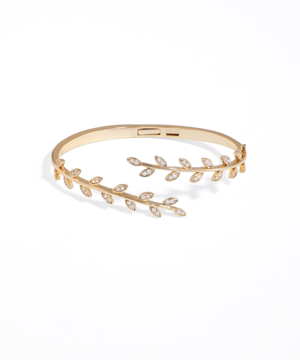 Gold bracelet with leaf design on a white background