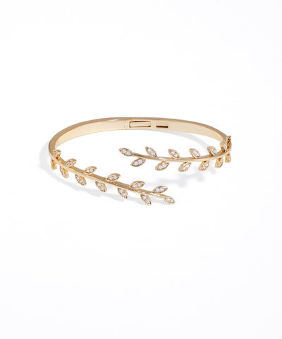 Gold bracelet with leaf design on a white background