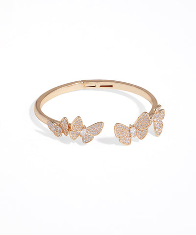 Rose gold bracelet with butterfly charms on a white background
